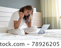 Asian woman lying down and smiling the bed and laptop 78926205