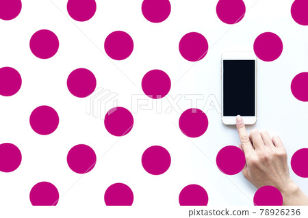 Female hand polka dot pink operating a smartphone Female hand polka dot pink operating a smartphone 78926236
