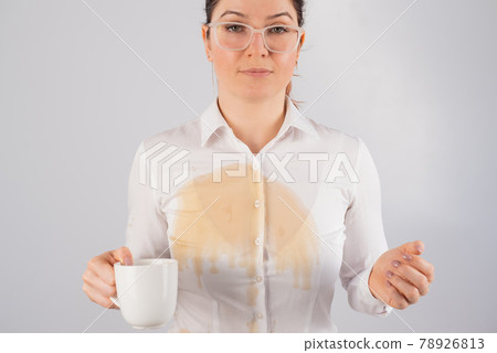 Clumsy business woman spills a cup of black coffee on her blouse. 78926813