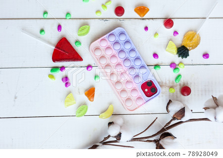 Phone case with pop it on white wooden background 78928049