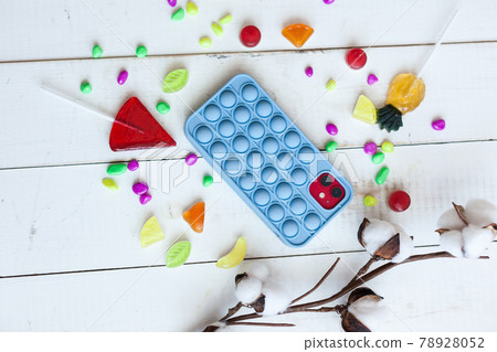 Phone case with pop it on white wooden background 78928052