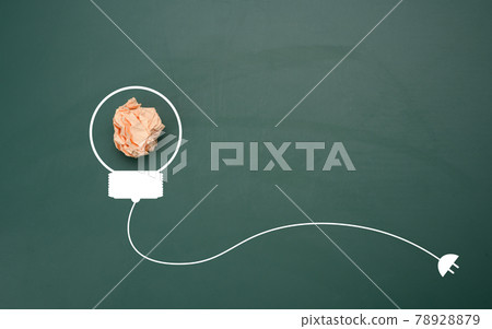 crumpled sheet of paper on a green background, shape of a light bulb. Energy saving concept crumpled sheet of paper on a green background, shape of a light bulb. Energy saving concept 78928879