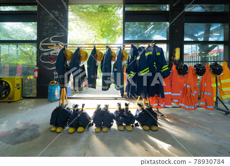Firefighting or fireman clothes on rack at fire station storage, an emergency accident rescue safety and security equipment Firefighting or fireman clothes on rack at fire station storage, an emergency accident rescue safety and security equipment 78930784