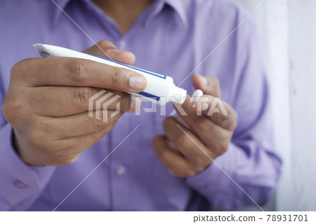 Man applying antibiotic cream close up Man applying antibiotic cream close up 78931701