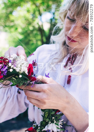 Young woman posing in traditional folk costume. Cossack girl in a wreath and embroidered shirts. Reconstruction of old traditions and customs. Vintage historical outfit 78932279