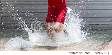 Splashing of water in the steeplechase as a runner is trying to run out Splashing of water in the steeplechase as a runner is trying to run out 78932681