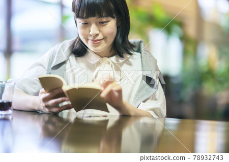 一個年輕女子在溫暖的氣氛中讀書 一個年輕女子在溫暖的氣氛中讀書 78932743