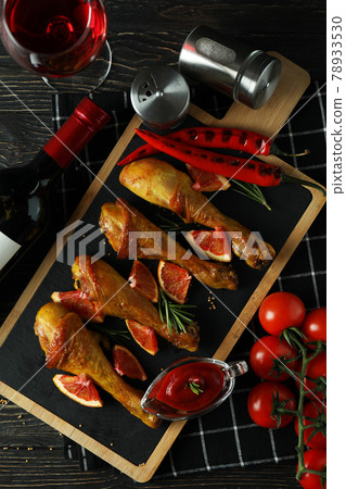Concept of delicious eating with board of roast chicken drumsticks on wooden table 78933530