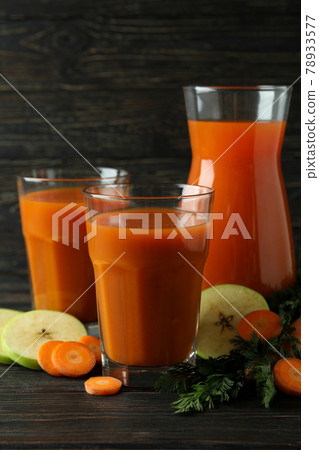 Glasses and pitcher with juice and ingredients on wooden background Glasses and pitcher with juice and ingredients on wooden background 78933577
