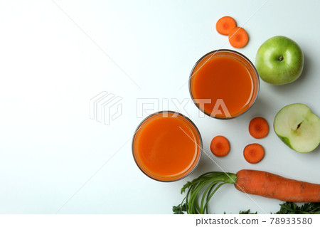 Glasses with juice and ingredients on white background 78933580