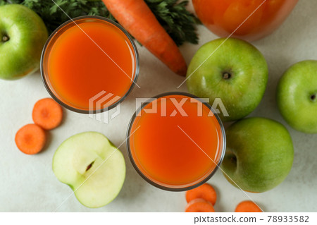 Glasses with juice and ingredients on white textured background 78933582