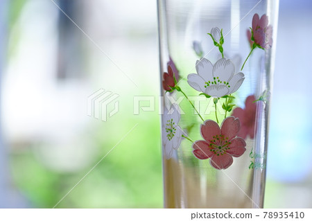 A cute floral glass by the window 78935410