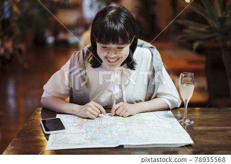 A young woman looking at a map in a fashionable space 78935568