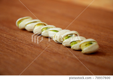Salted pistachio nuts on wood texture background. Salted pistachio nuts on wood texture background. 78937600
