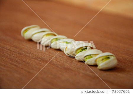 Salted pistachio nuts on wood texture background.    78937601