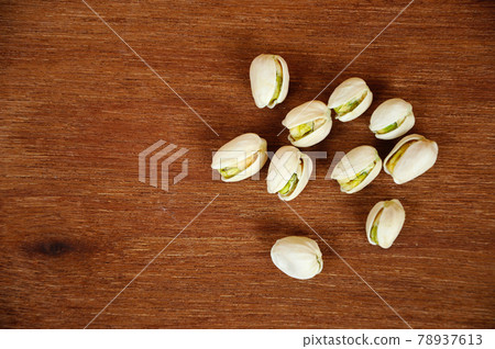 Salted pistachio nuts on wood texture background. Salted pistachio nuts on wood texture background. 78937613