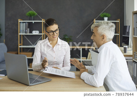 Senior client visits bank agent, financial adviser or insurance consultant in her office 78937644