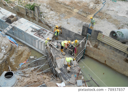SELANGOR, MALAYSIA -DECEMBER 02, 2016: Construction workers laying precast concrete drain at the construction site.  78937837