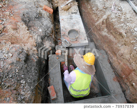 SELANGOR, MALAYSIA -DECEMBER 02, 2016: Construction workers laying precast concrete drain at the construction site.  78937839