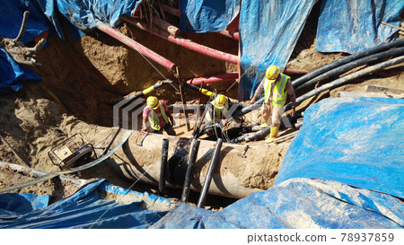 SELANGOR, MALAYSIA -NOVEMBER 03, 2016: Underground utilities trenches. Construction workers digging trenches to lay and install underground utility or services pipes at the construction site.  78937859
