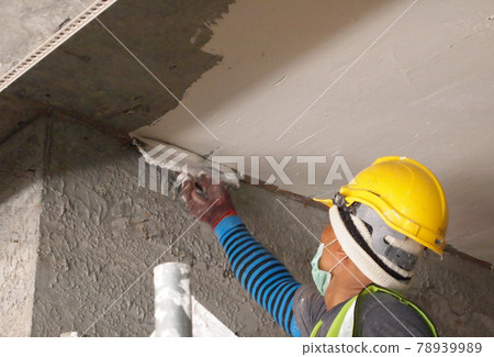 SELANGOR, MALAYSIA -SEPTEMBER 06, 2016: Construction site workers are doing concrete ceiling soffit skim coat work at the construction site. Two layers apply to get the smooth surface.  78939989