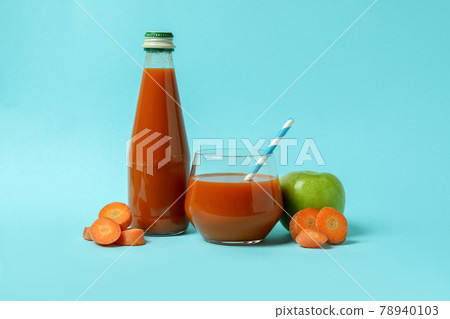 Bottle and glass of juice and ingredients on blue background 78940103