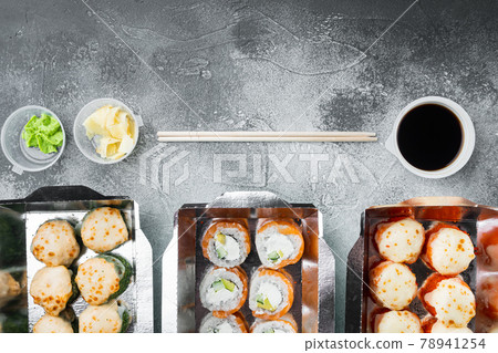 Sushi rolls in takeaway container, on gray stone background, top view flat lay , with copyspace and space for text 78941254