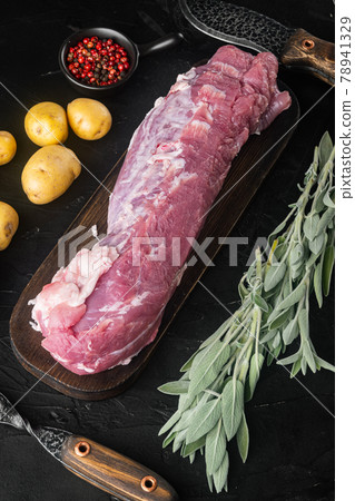 Raw Pork fillet with sage, on wooden cutting board , with barbeque knife and meat fork, on black stone background, top view flat lay Raw Pork fillet with sage, on wooden cutting board , with barbeque knife and meat fork, on black stone background, top view flat lay 78941329