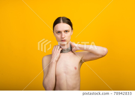 Feminine young man with metal chain. Slender body Feminine young man with metal chain. Slender body 78942833