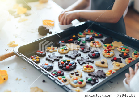 Children put candy cookies on a baking sheet. Leisure activity with children concept Children put candy cookies on a baking sheet. Leisure activity with children concept 78943195
