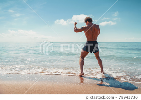 A muay thai or kickboxer training with shadow boxing outdoor at seashore A muay thai or kickboxer training with shadow boxing outdoor at seashore 78943730
