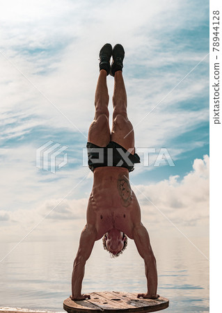Young man is doing street workout. Handstand exercise, bodyweight Young man is doing street workout. Handstand exercise, bodyweight 78944128