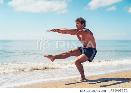 Muscular man doing exercise on beach. Body training 78944471