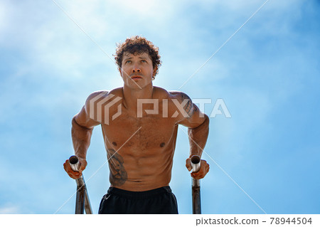 Fit Man Workout Out Arms On Dips Horizontal Bars Training Triceps And Biceps Doing Push Ups. Handsome Man Doing Exercise On Parallel Bars. Male Athlete Exercises On Parallel Bars Outdoor Fit Man Workout Out Arms On Dips Horizontal Bars Training Triceps And Biceps Doing Push Ups. Handsome Man Doing Exercise On Parallel Bars. Male Athlete Exercises On Parallel Bars Outdoor 78944504
