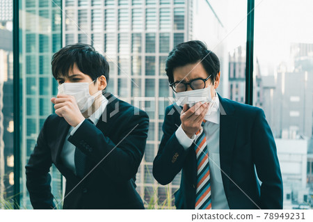 Two young businessmen coughing in masks Two young businessmen coughing in masks 78949231