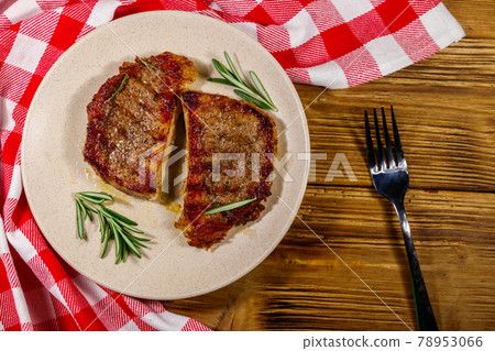 Grilled pork steaks with rosemary on wooden table. Top view 78953066