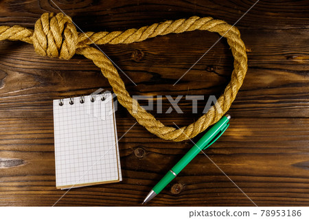 Deadly loop of rope and suicide note on a wooden background. Concept of suicide Deadly loop of rope and suicide note on a wooden background. Concept of suicide 78953186
