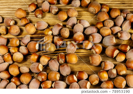Heap of hazelnuts on a wooden table Heap of hazelnuts on a wooden table 78953190