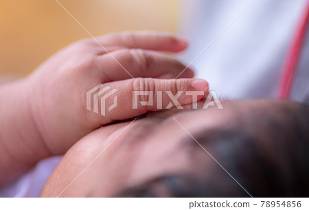 Three weeks old adorable infant baby girl's hand on her face, sleeping cute small Sri Lankan baby close up hand and fingers. Three weeks old adorable infant baby girl's hand on her face, sleeping cute small Sri Lankan baby close up hand and fingers. 78954856