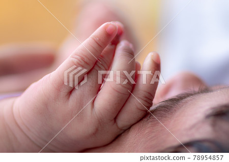 Three weeks old adorable infant baby girl's hand on her face, sleeping cute small Sri Lankan baby close up hand and fingers. Three weeks old adorable infant baby girl's hand on her face, sleeping cute small Sri Lankan baby close up hand and fingers. 78954857