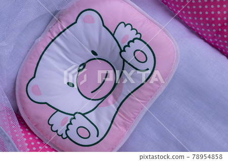 Cute little pink color pillow on an infant baby's crib, view from top close up photo. Cute little pink color pillow on an infant baby's crib, view from top close up photo. 78954858