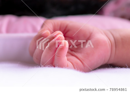 Baby hand resting on white fluffy clean cloth, newly born, 3 weeks old healthy baby girls hand upside close up photograph, fingers are so small and adorable pink color. sleeping beauty concept image. Baby hand resting on white fluffy clean cloth, newly born, 3 weeks old healthy baby girls hand upside close up photograph, fingers are so small and adorable pink color. sleeping beauty concept image. 78954861