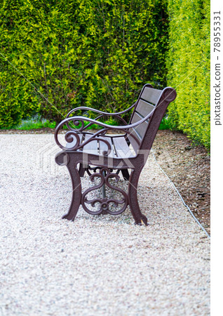 A bench in front of the blue fence in the park 78955331