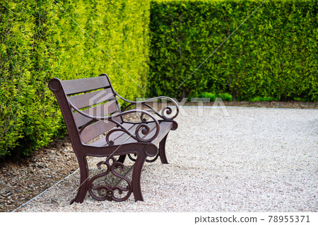 A bench in front of the blue fence in the park A bench in front of the blue fence in the park 78955371