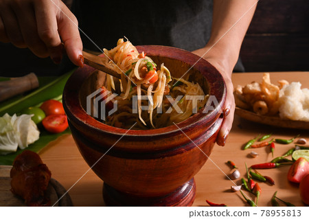 Female making papa salad in mortar. Thai food concept. 78955813