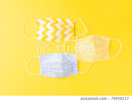 Eco-friendly reusable cloth protective mask yellow background. Homemade breathing mask, protection against corona virus Eco-friendly reusable cloth protective mask yellow background. Homemade breathing mask, protection against corona virus 78956517