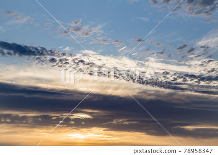 Beautiful blue sky at sunset with golden fluffy clouds.  78958347