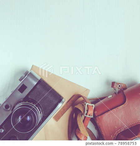 Vintage camera with leather case and craft paper envelope on a wooden white background. Copy space. square format, toned Vintage camera with leather case and craft paper envelope on a wooden white background. Copy space. square format, toned 78958753