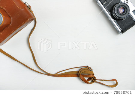 Vintage camera with leather case on a wooden white background. Copy space. toned Vintage camera with leather case on a wooden white background. Copy space. toned 78958761