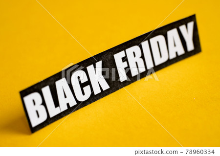 Black Friday sticker on a yellow background. Close up. Black Friday sticker on a yellow background. Close up. 78960334
